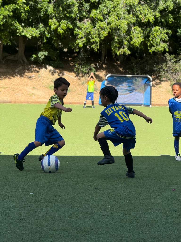 Kids playing soccer on a turf field